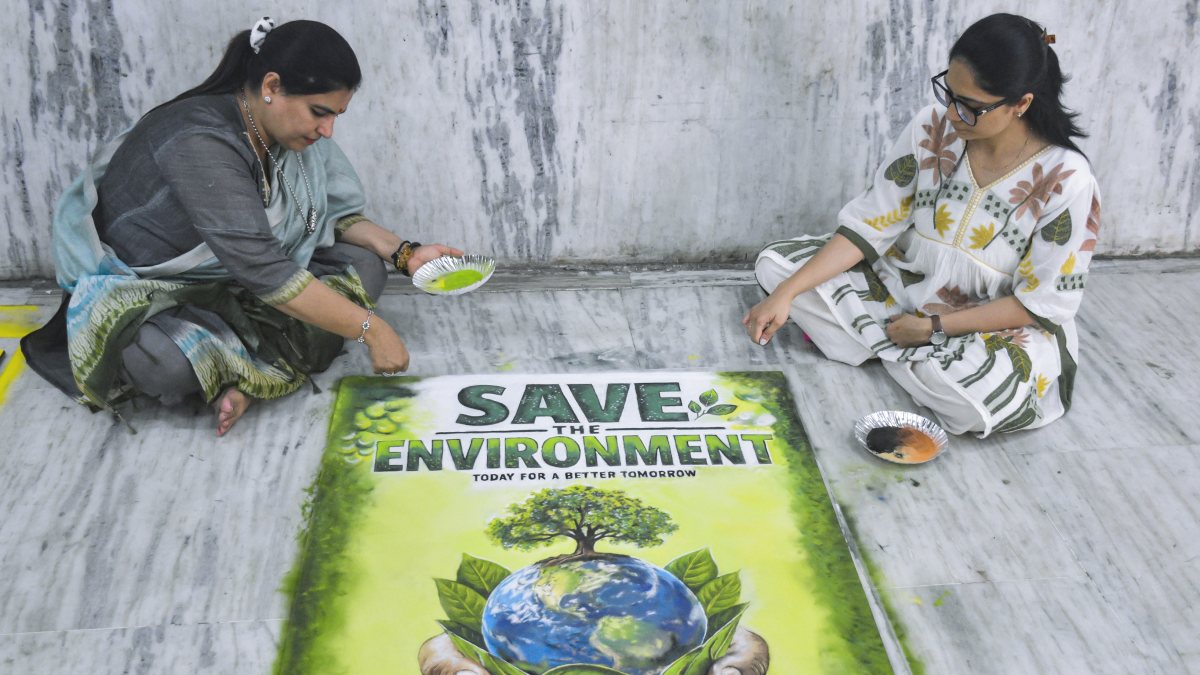 Women prepare an eco-themed rangoli as part of the celebration ahead of Prime…