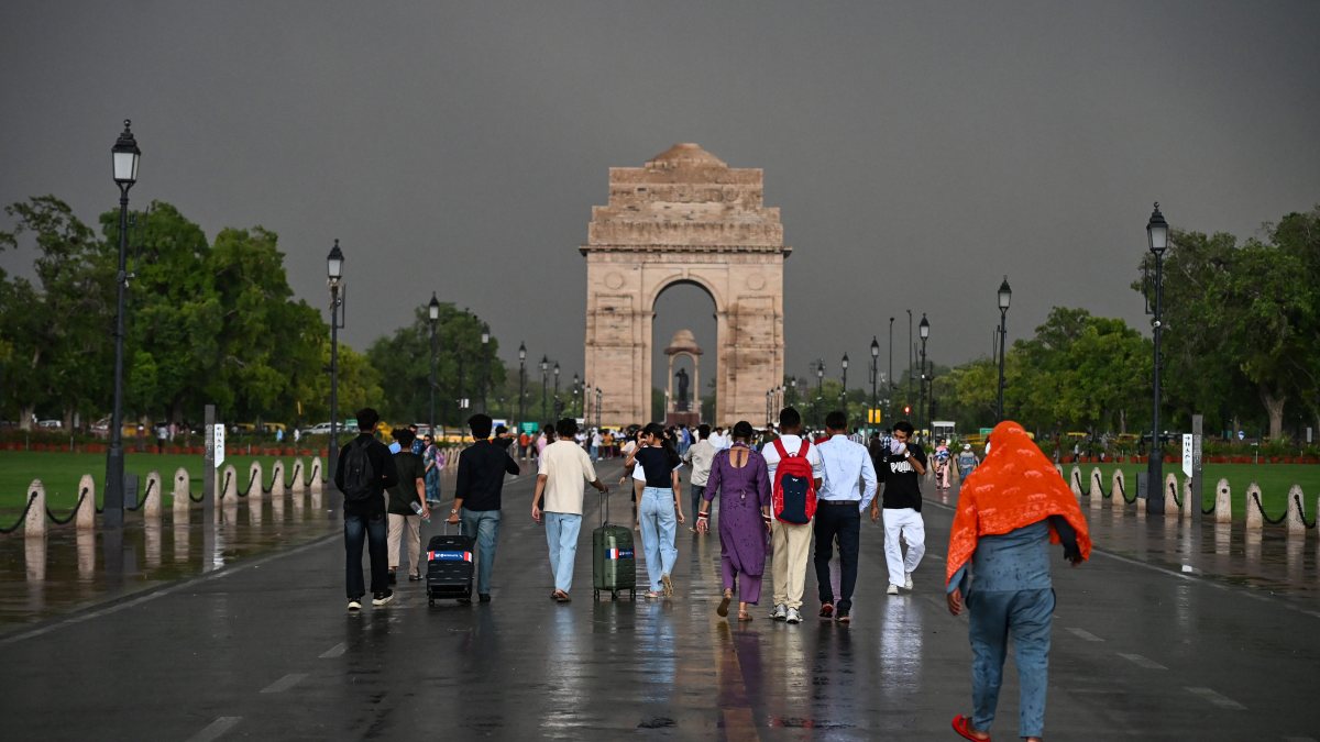 People walk in rain at Kartavya Path in New Delhi