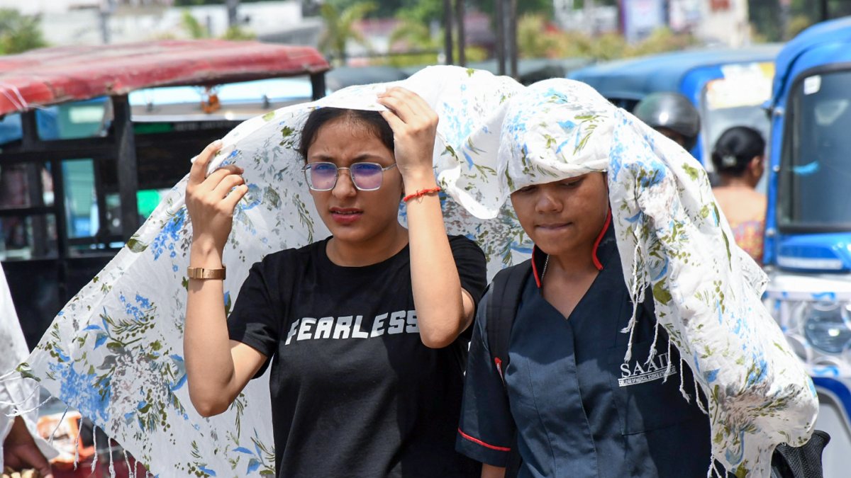 Women cover their heads with a scarf to protect themselves from the scorching…
