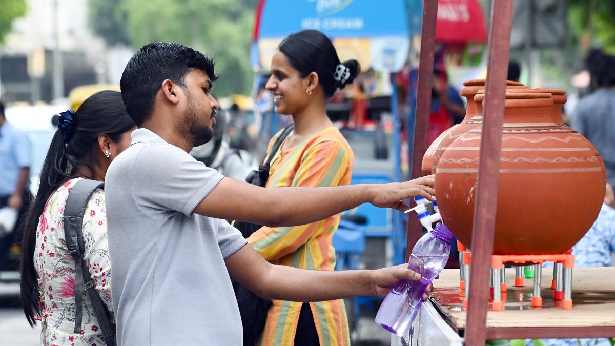 Man fills water bottle from earthen pot to beat Delhi heat