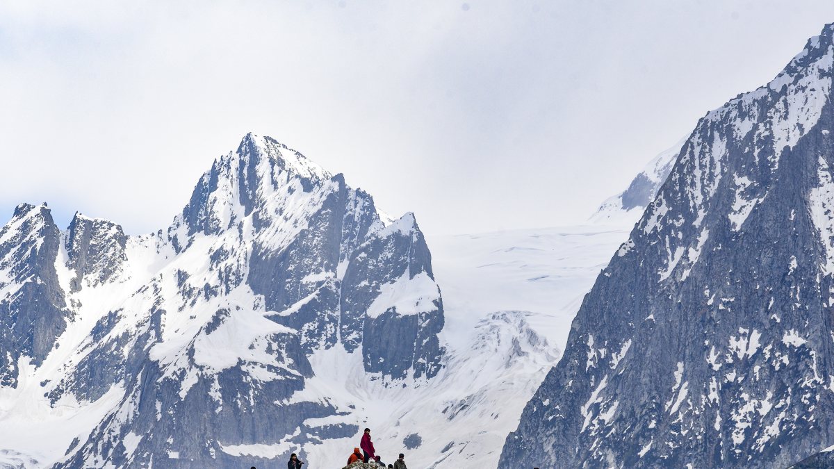 Tourists rest atop a mountain at Sonmarg in Ganderbal
