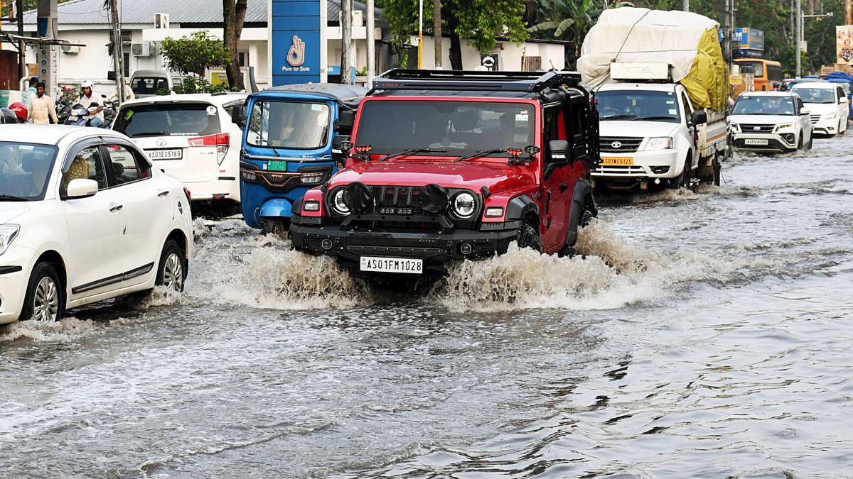 Vehicles wade through waterlogged street after rainfall in Guwahati