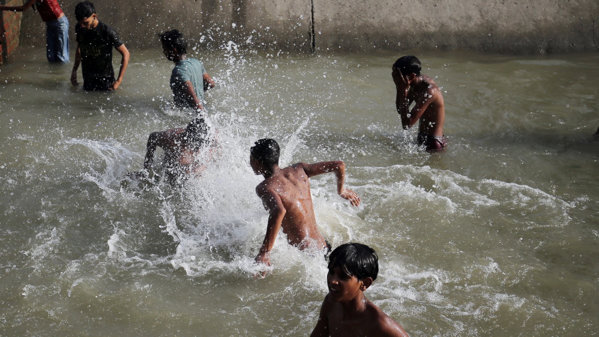 Children cool off in canal drain amid Amritsar heatwave