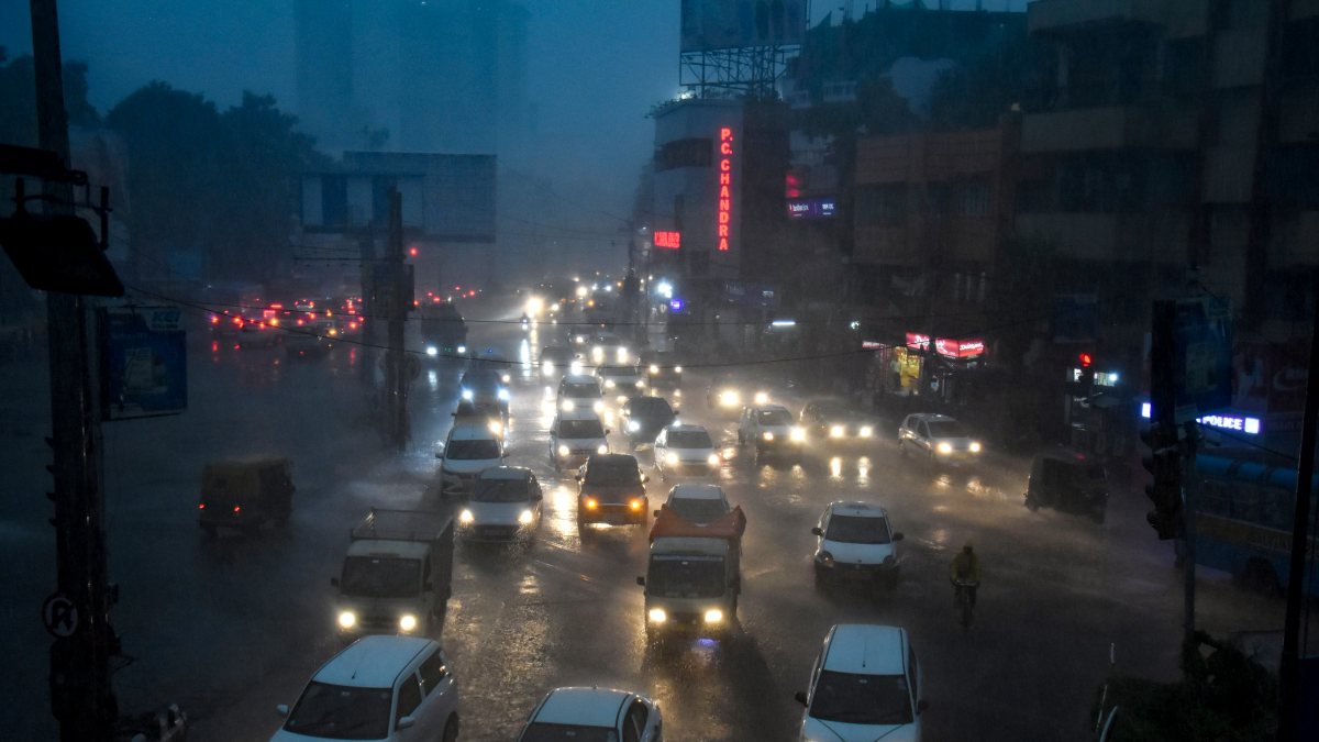 Vehicles wade through a water-logged street after a spell of heavy rains, in…