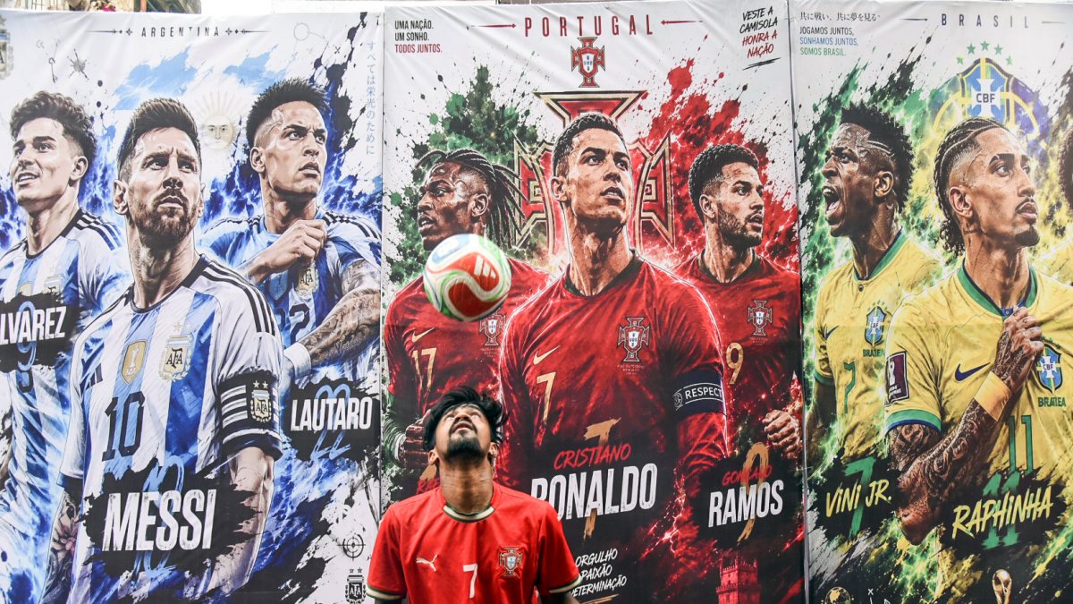 Boy controls football beside wall with Portugal, Argentina, Brazil posters