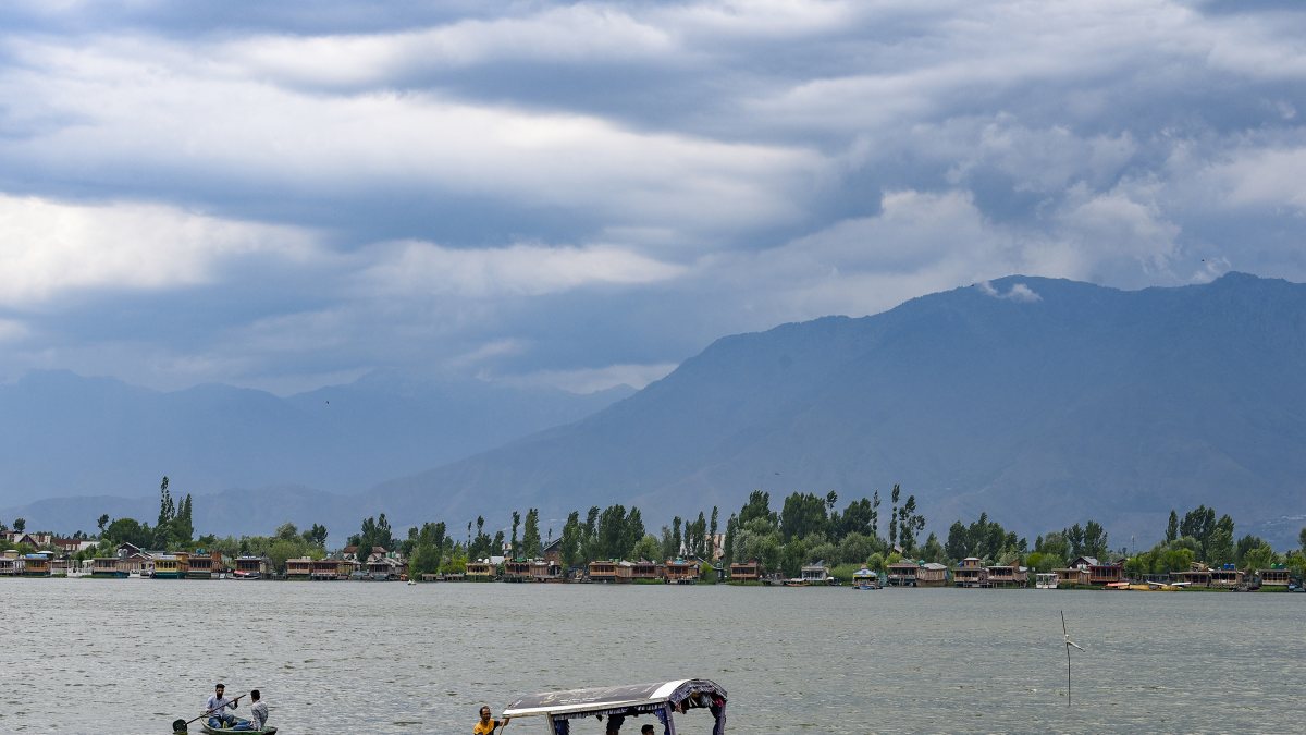 Tourists enjoy shikara ride on Dal Lake under cloudy skies