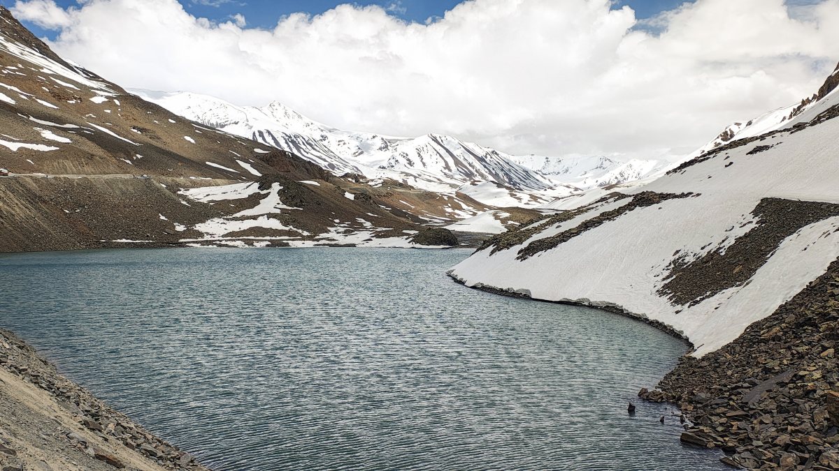 A view of the Suraj Tal Lake surrounded by snow-clad mountains, in Lahaul and…
