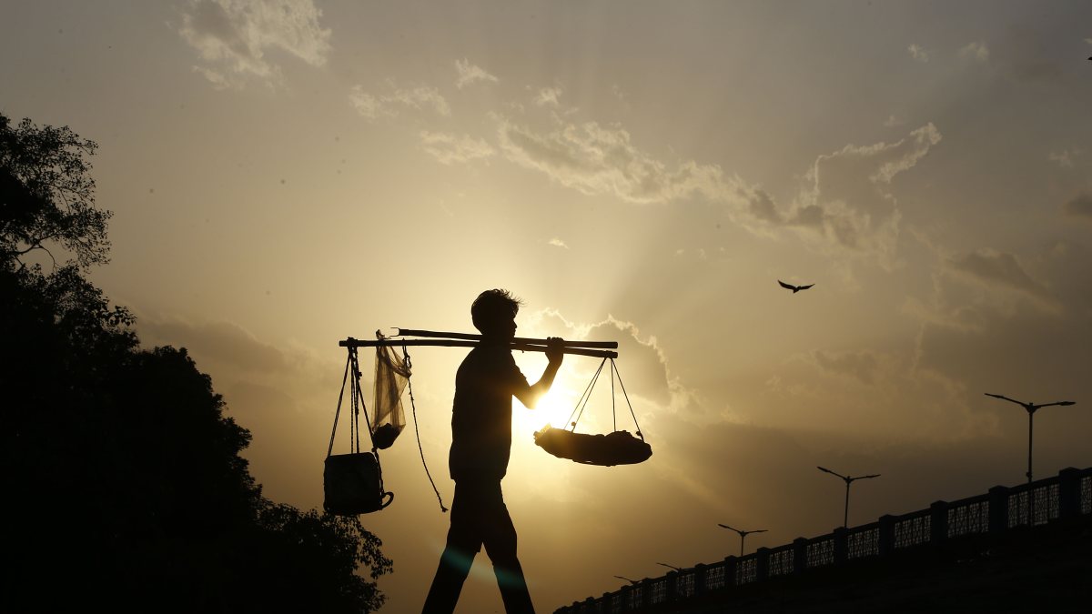 A snack vendor walks near the Sardar Bridge to sell his snacks, in Ahmedabad on…