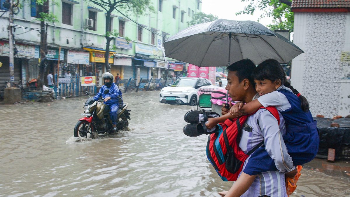 Guardian carries student through waterlogged Kolkata road