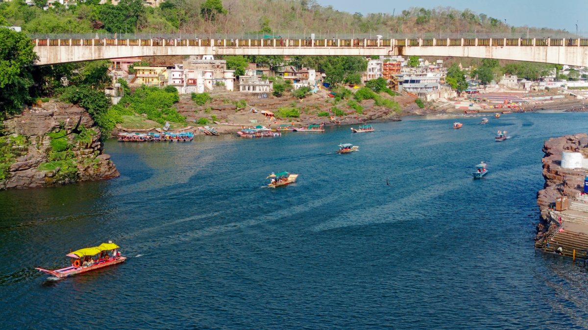 Devotees take a boat ride on the Narmada River at Omkareshwar