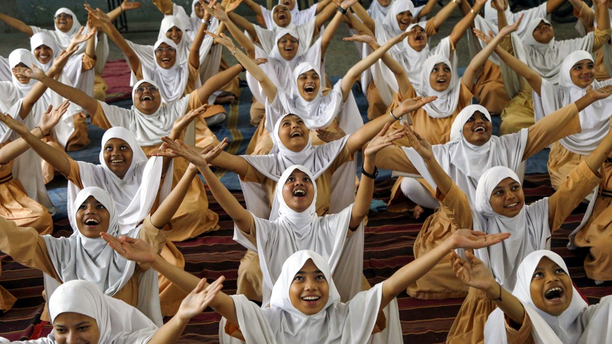 Students participate in a yoga practice session at Anjuman-E-Islam High School…