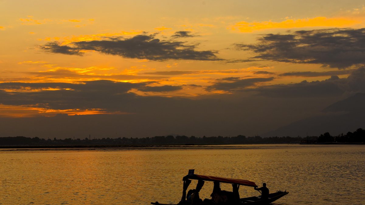 A man rows a boat during sunset over Dal Lake, in Srinagar on Saturday.