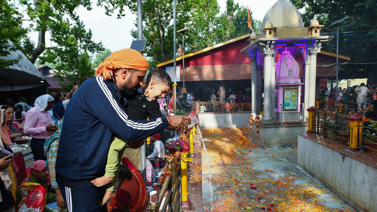 Devotee offers milk with child at Mata Kheer Bhawani Temple in Ganderbal