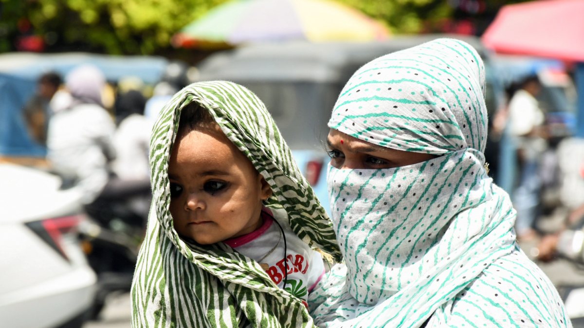 Woman shields child from scorching heat in Kanpur