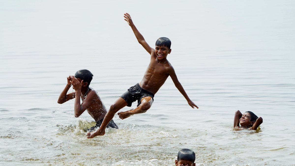 Children enjoy a refreshing dip as the mercury continues to soar, in Morigaon…