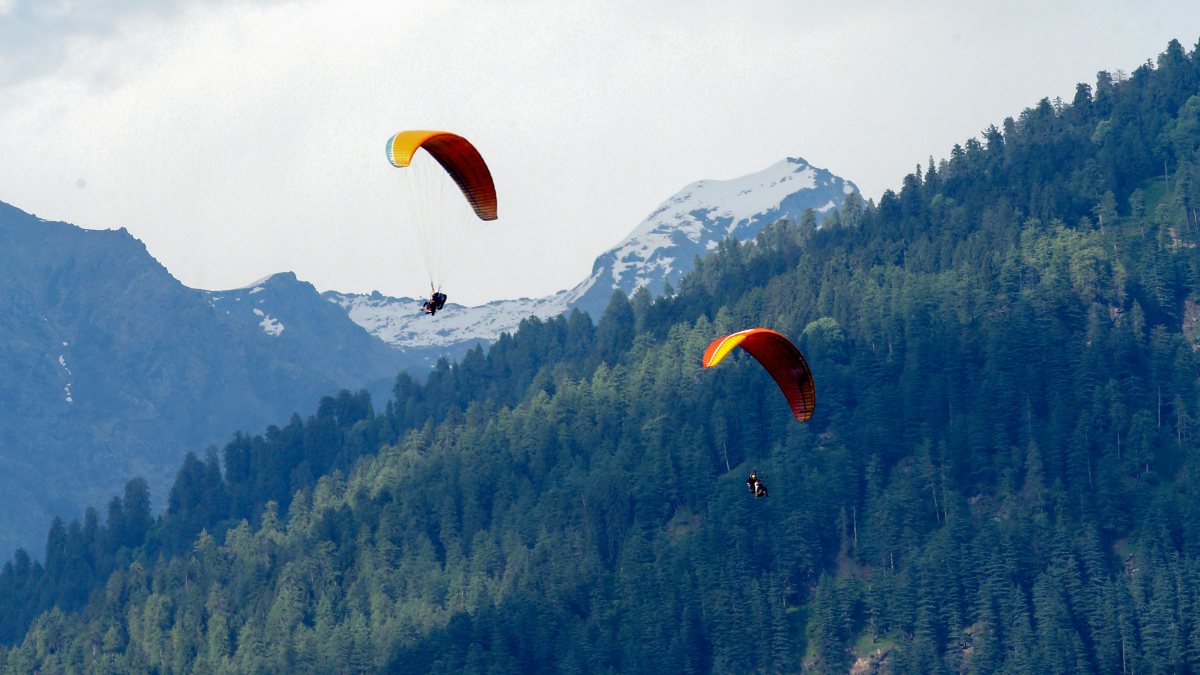 Tourists enjoy paragliding over the 'Verdant Valley' (or Kullu Valley) at…