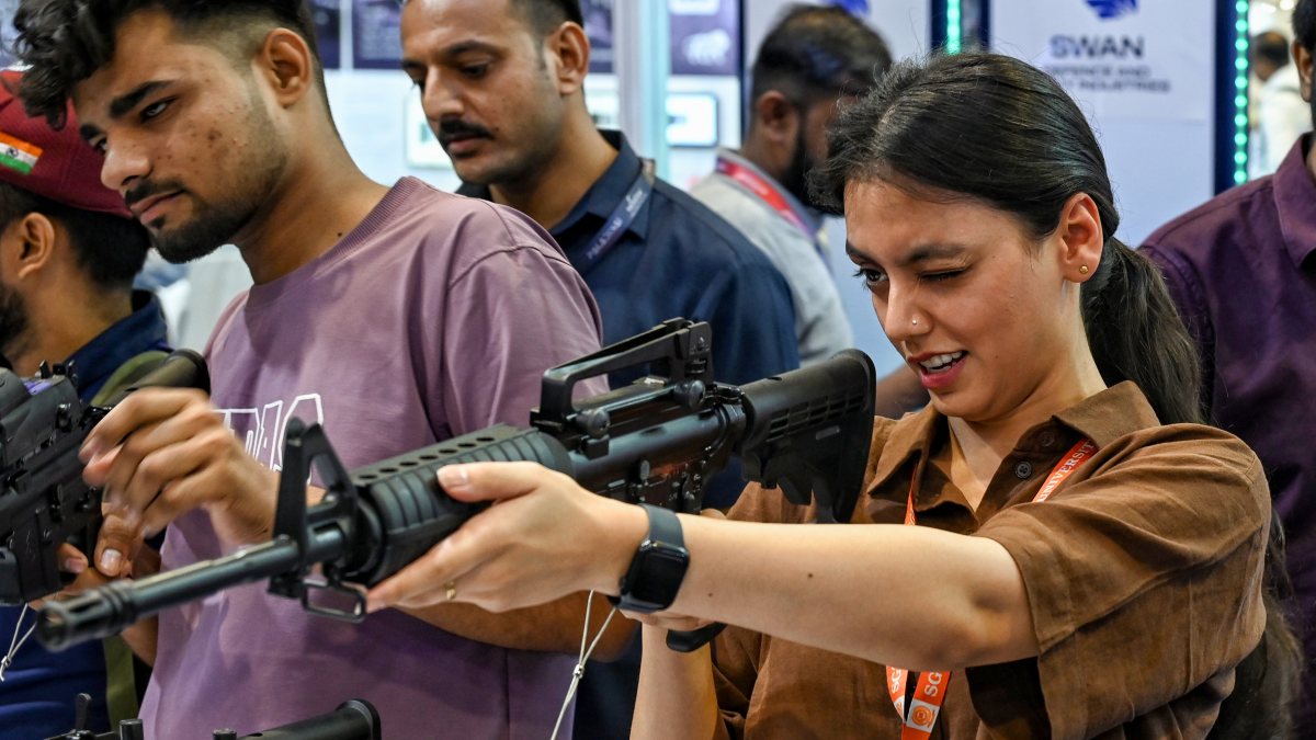 Visitor holds gun at AI-powered police expo in New Delhi