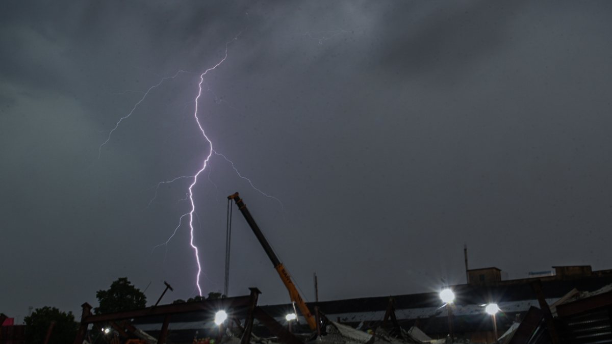 Lightning flashes over collapsed warehouse site in Kolkata