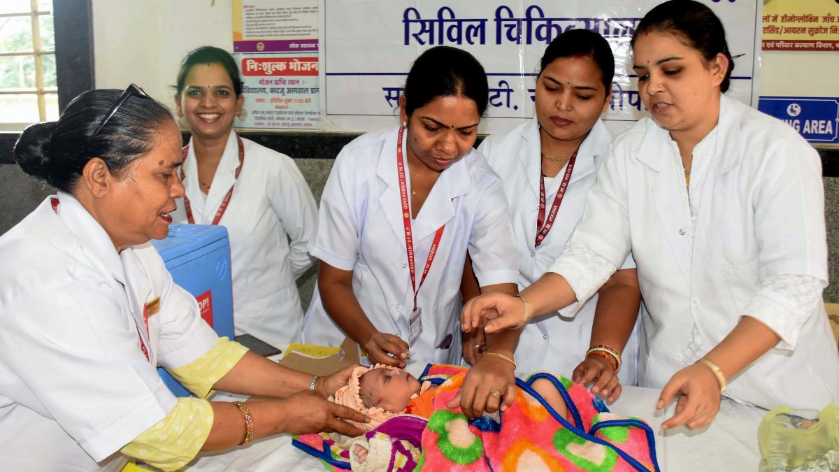 Health workers administer polio drops to infant in Bhopal
