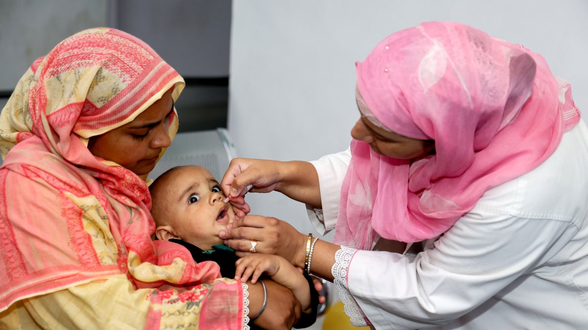Health worker gives polio drops to child in Srinagar campaign