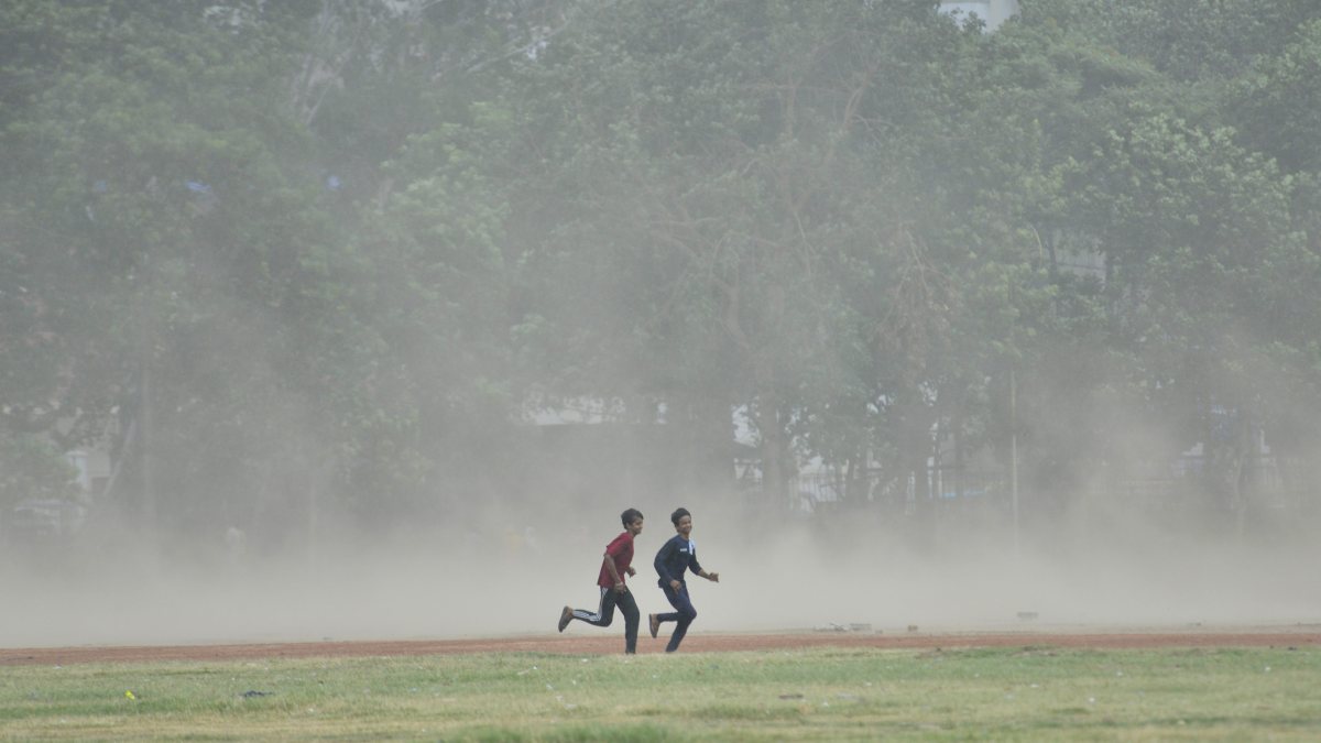 Children run through dust-storm in Patna