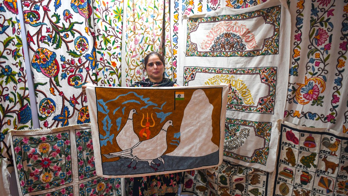 An artisan displays Kashida rugs and carpets at the stall during the…