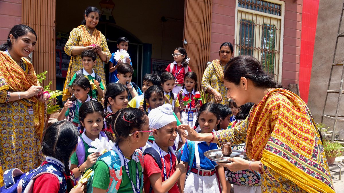 Teacher applies tilak to student on first day of school in Bikaner