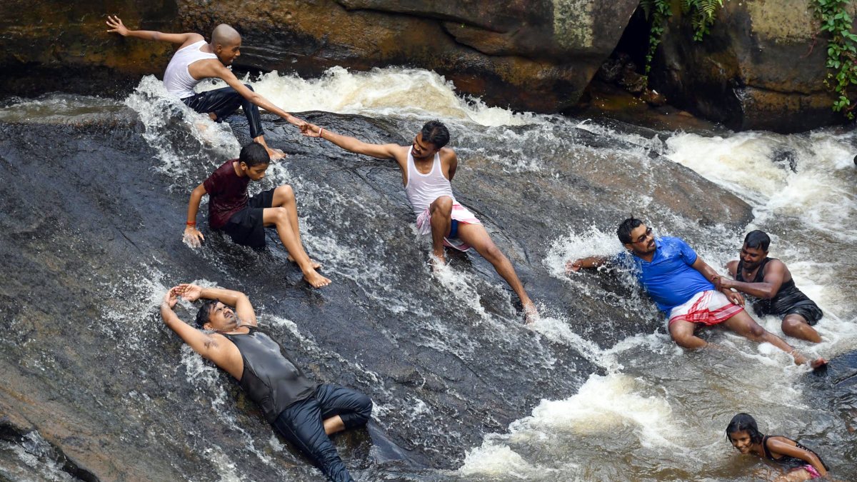 Locals take a refreshing dip at the Basistha River amid a hot summer day, in…