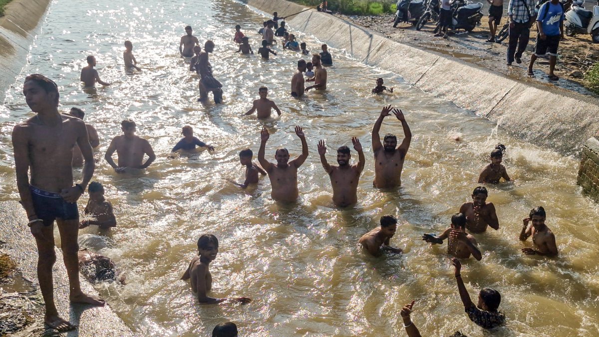 Youngsters cool off in canal on humid Amritsar day