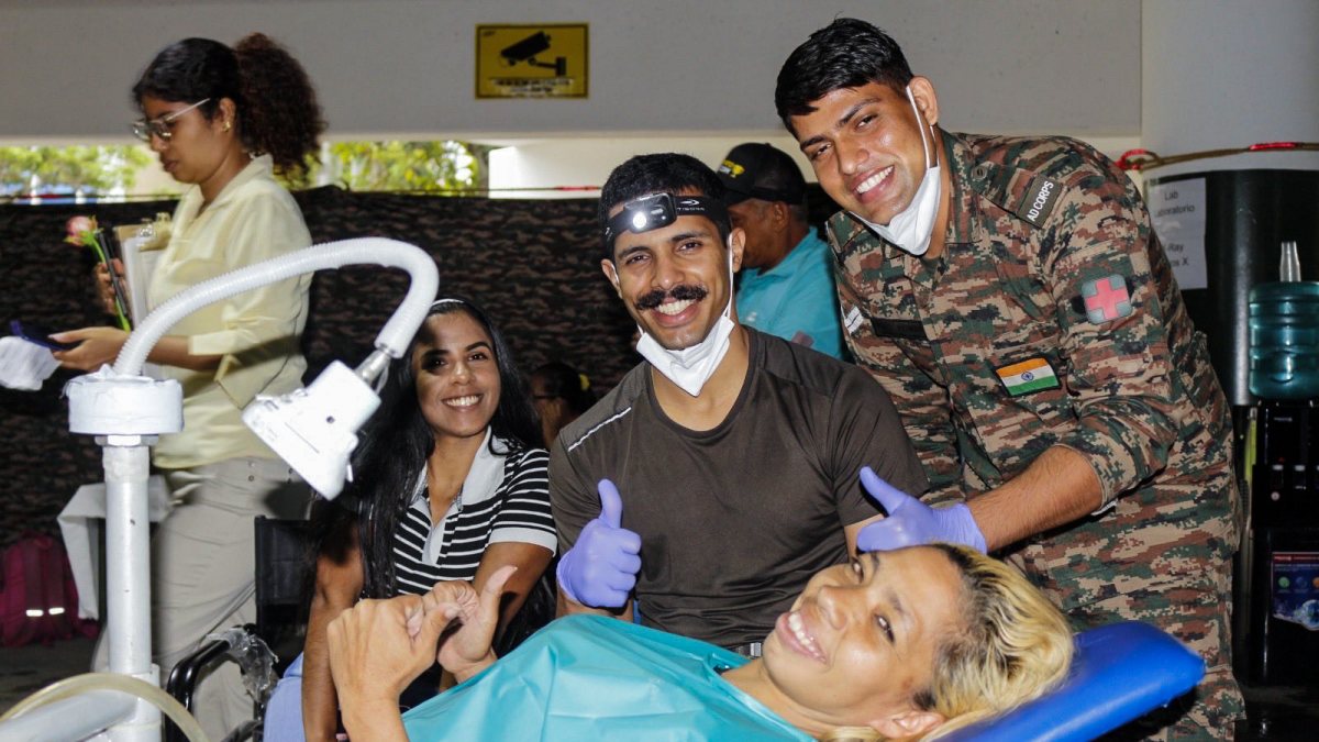 A patient and Indian Army medical personnel pose for a photo at a field…