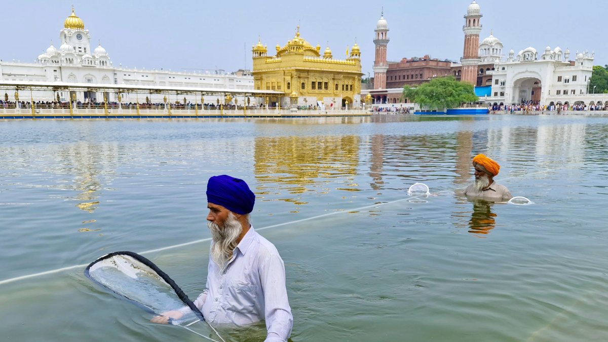 Sikh volunteers clean the sacred pond of the Golden Temple, in Amritsar on…