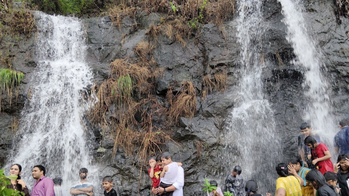 People enjoy at the waterfalls near Mumbra Hills, in Thane on Sunday.