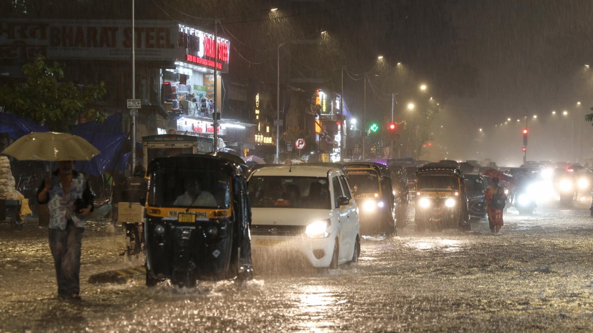 Mumbai commuters wade through waterlogged roads amid heavy rain