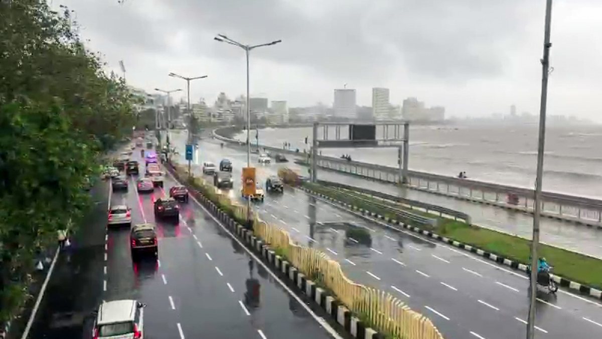 Vehicles ply on rain-lashed Marine Drive amid rough sea in Mumbai