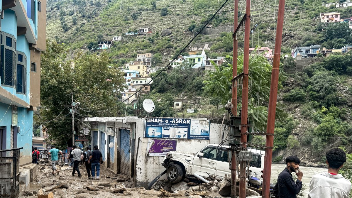 Flood debris litters Doda streets as residents walk through