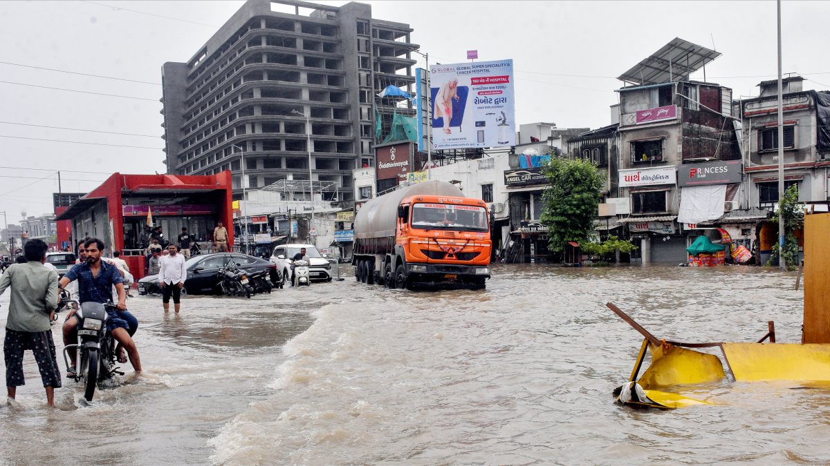 A truck wades through a waterlogged road following heavy rainfall, in Surat on…