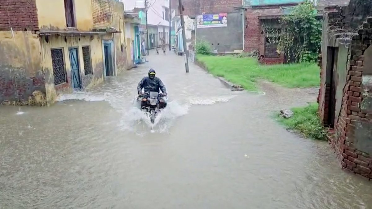 Biker navigates waterlogged road amid heavy rain in Bulandshahr