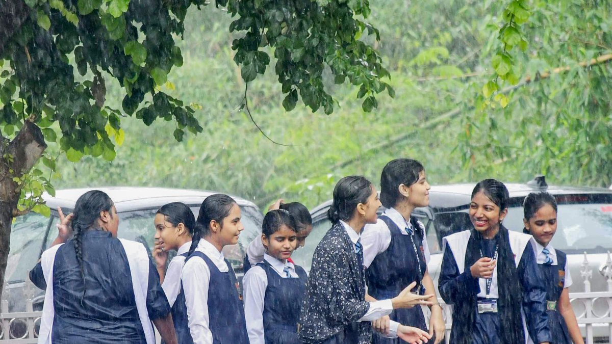 School students brave heavy rain on Prayagraj sidewalk