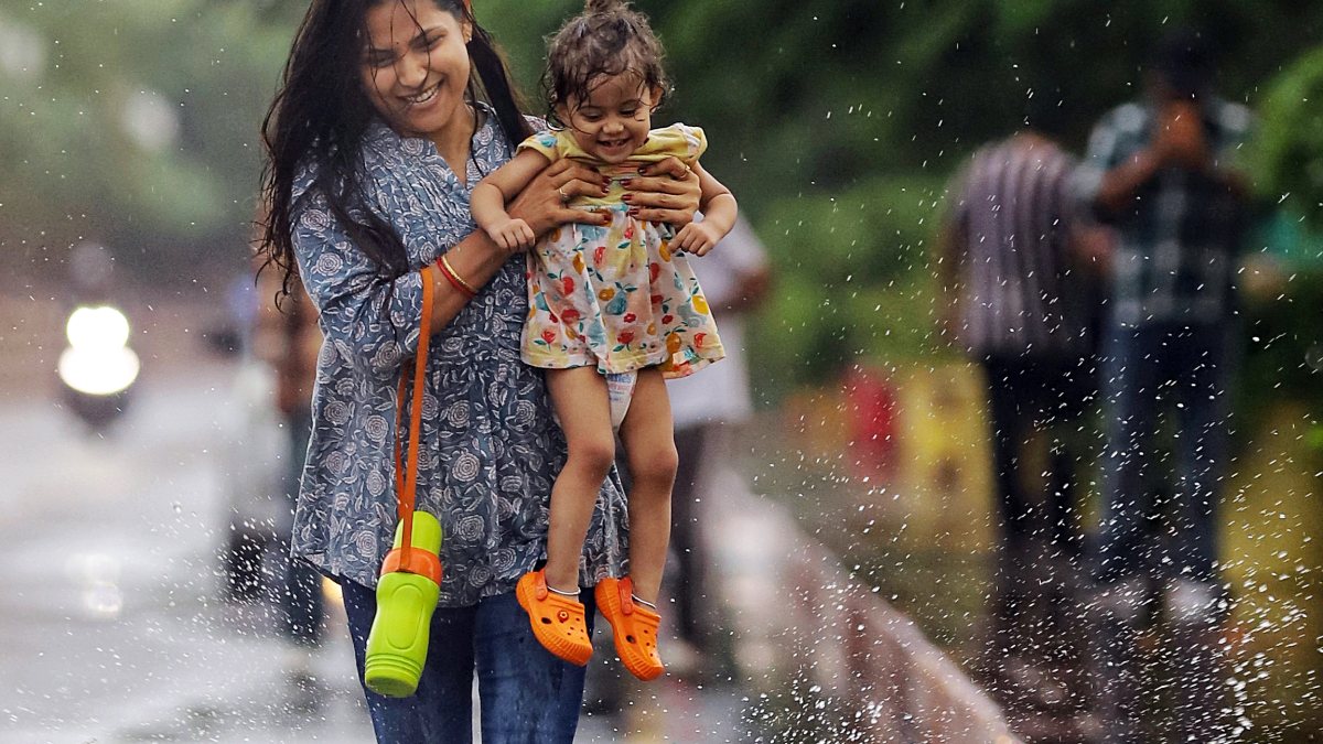 Woman and daughter enjoy rain in Lucknow