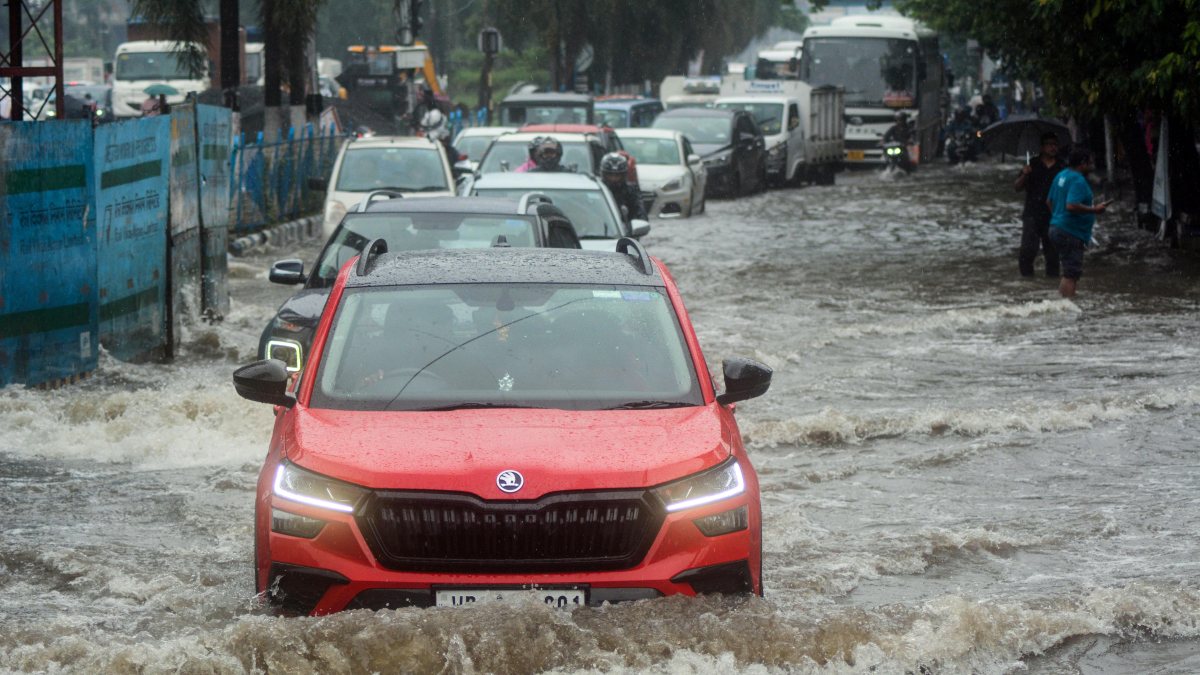 Vehicles wade through waterlogged Kolkata street after heavy rain