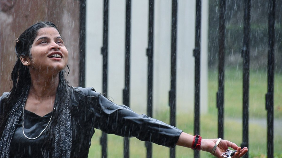 Woman enjoys the rain in Varanasi