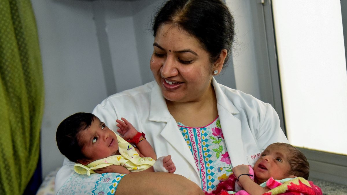 Doctor poses with newborns on World Population Day in Bikaner
