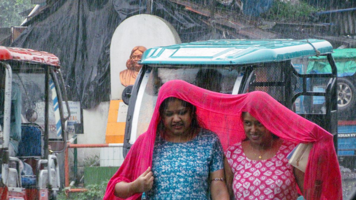 Heavy rain forces women to shield themselves with stoles in Nadia