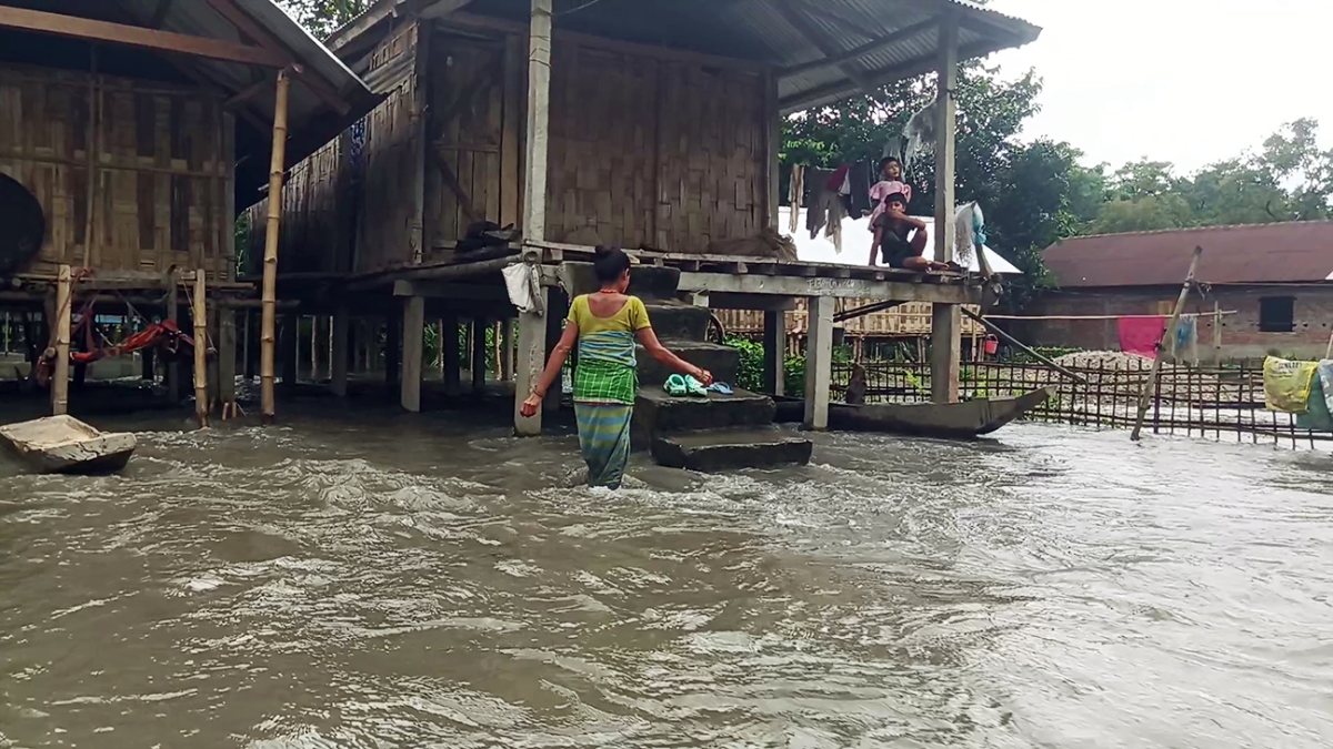 Villager wades through floodwaters in Assam's Lakhimpur