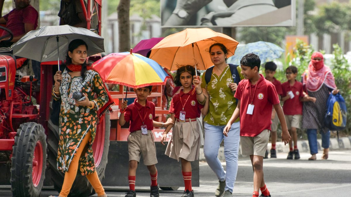 Students and mothers brave heat on return from school