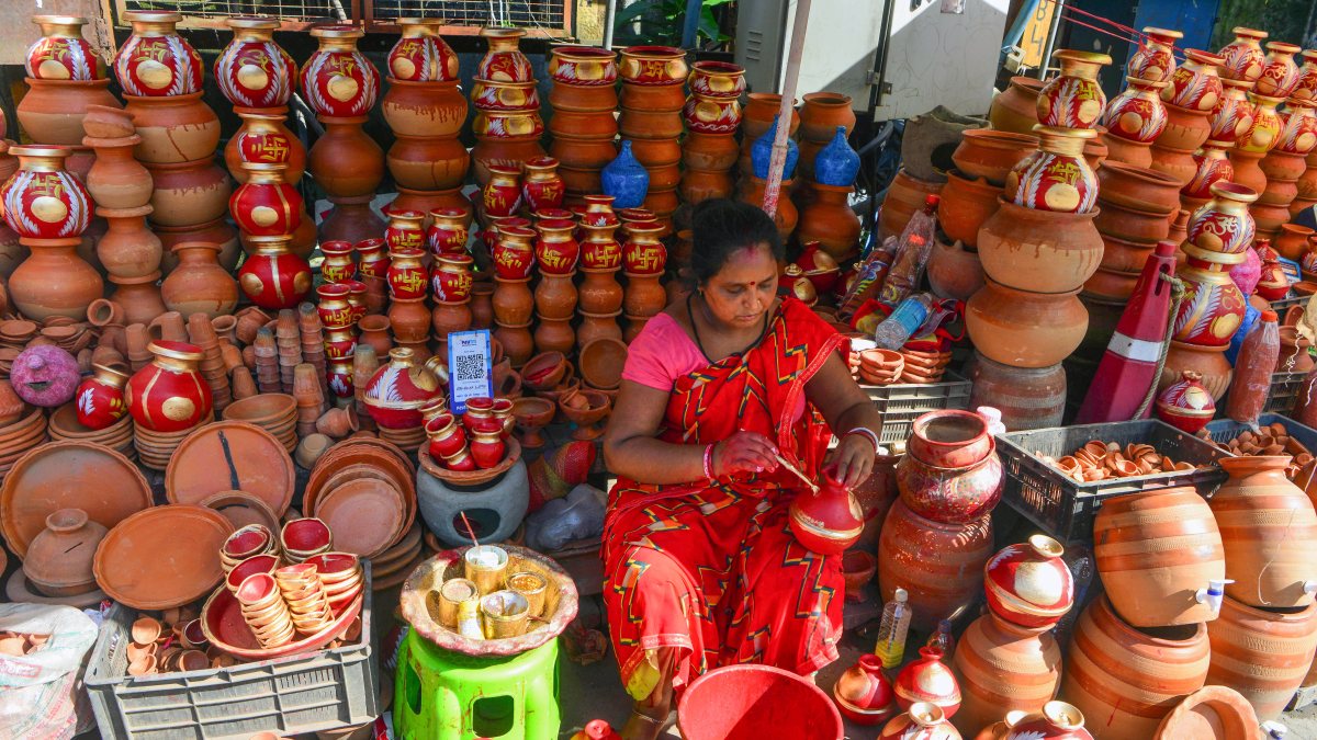 Woman paints earthen pots at roadside shop in Siliguri