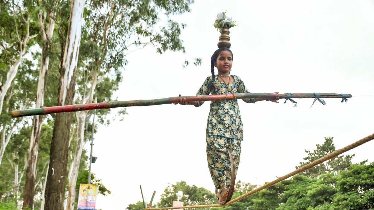 Girl performs rope stunt with fire pots at Jharkhand temple fair