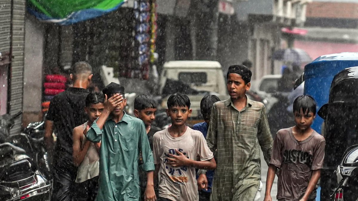 Children walk through flooded street in Haldwani amid heavy rain