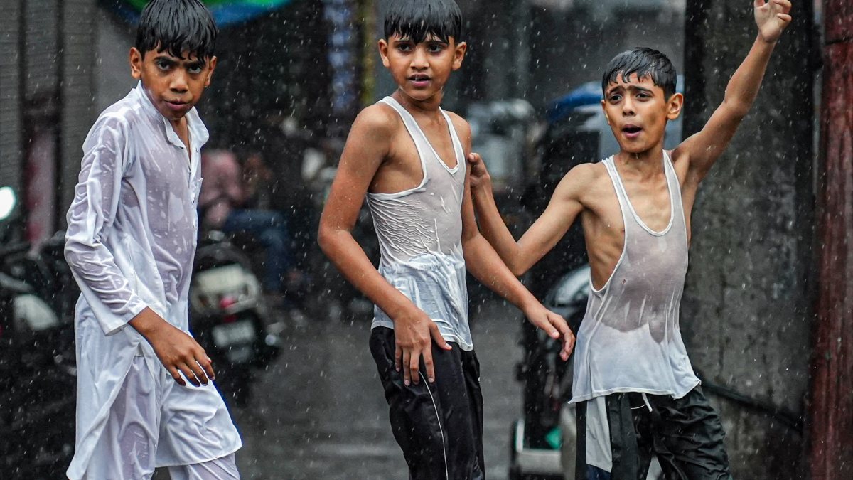 Children walk through flooded street in Haldwani amid heavy rain