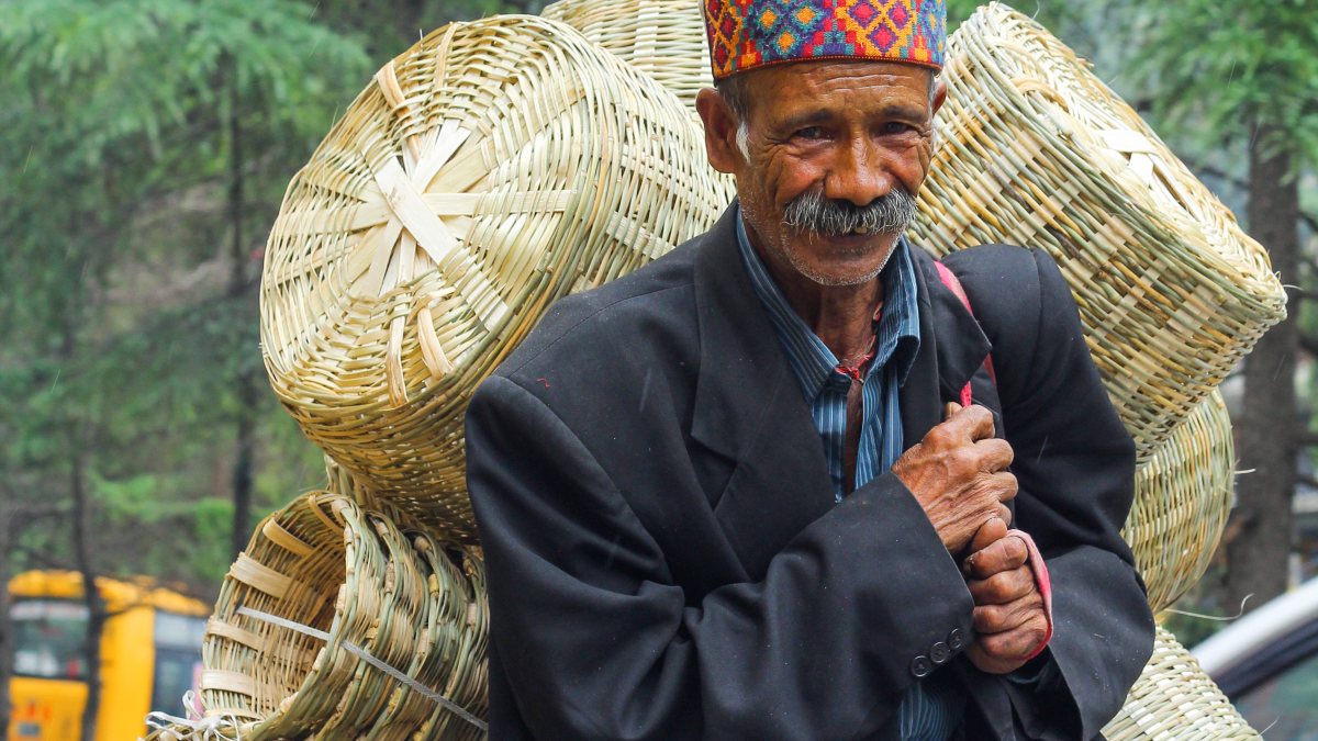 Man carries bamboo baskets to sell at Kullu market